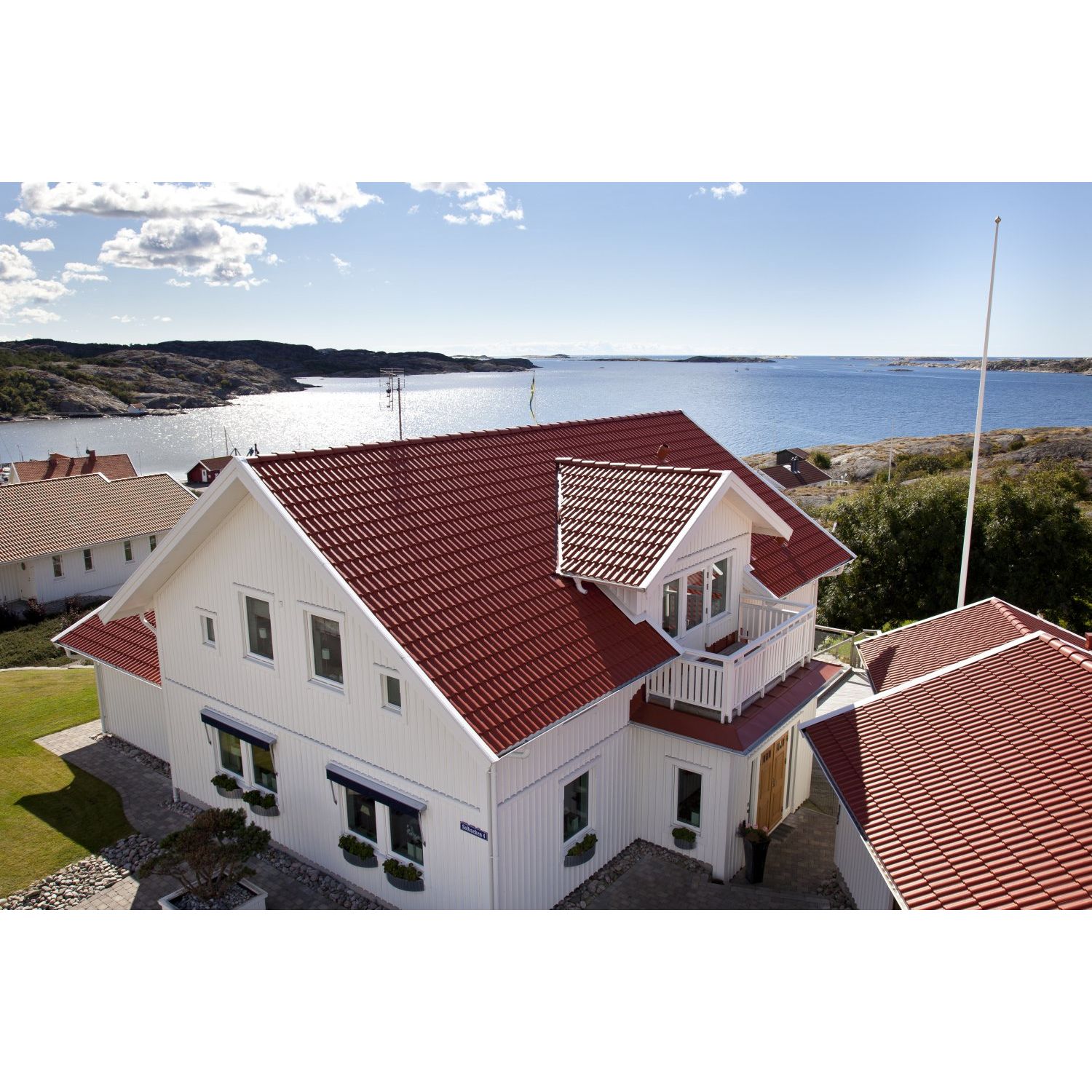 Punainen tiilikatto, valkoinen puutalo ja sinisenä hohtava meri ovat yhdistelmä vailla vertaa!