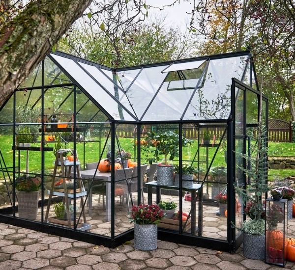 Kasvihuone asennettuna pihakivetysten päälle pihaympäristössä