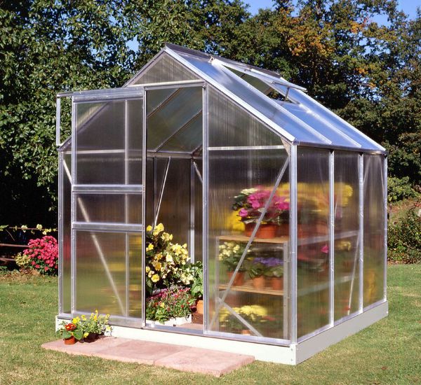 Kasvihuone Halls Popular asennettuna nurmikolle maahan tulevan perustuksen ja Halls-sokkelin varaan