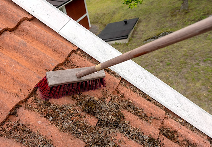 Katon puhdistaminen roskista harjalla